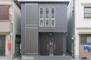 a brick building with a brown door and windows at 森の晴 in Osaka