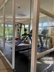 a gym with several tread machines and glass walls at Camella Manors Verdant Condo at Puerto Princesa for Family and Couples in Puerto Princesa City