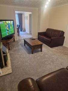 a living room with a couch and a tv at SK Short Let 