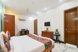 a bedroom with a bed and a television in it at FabHotel The Silken Stay in Gurgaon