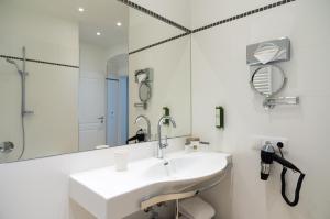 un bagno bianco con lavandino e specchio di Hotel Spiess & Spiess a Vienna
