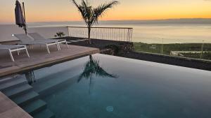 una piscina con sillas y vistas al océano en Casa Laina, en Tijarafe