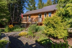 a log cabin with a porch and a garden at Ackerview Guesthouse Bed and Breakfast in Salmon Arm
