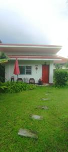 ein Haus mit einer roten Tür und einem Rasenplatz in der Unterkunft Smile house 354 in Chiang Rai + 13 Fotos