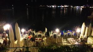 a group of people sitting at tables at night at Losta Sahil Evi 2 in Selimiye