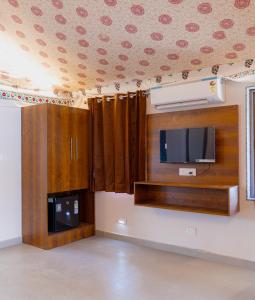 a living room with a tv and a wall with a tvictericter at Stayguru Road to Heaven Resort in Kunria