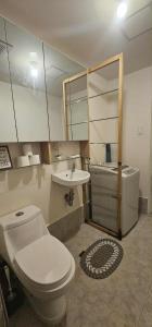 a bathroom with a toilet and a sink and a tub at Sweet Escape 311 at Amaia in Bacolod