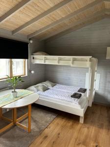 a bedroom with a bunk bed and a table at Holiday home Kolmårdsgården in Kolmården