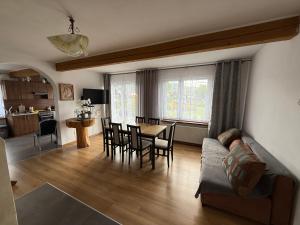a living room with a couch and a table and chairs at Pod Podwijką in Jeleśnia