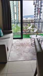 a living room with a couch and a table and chairs at MZS Studio Swiss Garden R in Kuantan +1 photo