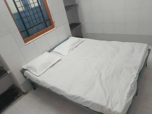 a bed with white sheets and a window in a room at SPOT ON Somani Paying Guest in Latur