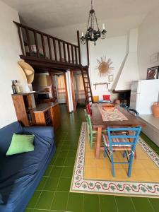 a living room with a blue couch and a table at Appartamento Sole e Mare in Santa Margherita di Pula