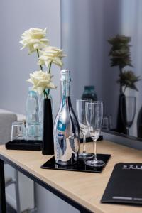 a table with a bottle and two glasses on it at Platynowa in Września
