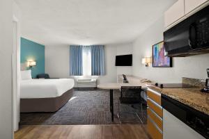 a hotel room with a bed and a kitchen at MainStay Suites Salt Lake City Fort Union in Midvale