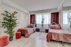 a bedroom with two beds and a potted plant at Panoramic Ocean Mountain View 3 in Adeje