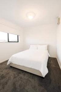 a white bedroom with a large white bed at CasaAria - Modern, Contemporary, Luxe Linens in Truganina