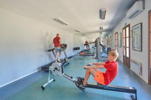 a young boy sitting on a treadmill in a gym at Résidence Château de Salles in Salles