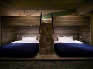 two twin beds in a room with two bedsskirts at Minn Ueno Iriya in Tokyo +24 photos