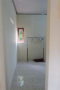 a white room with a window and a tiled floor at PW Homestay in Sleman +14 photos