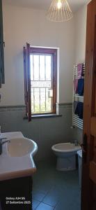 a bathroom with a sink and a toilet and a window at Ylenia Summer Beach in LʼAmericano +16 photos