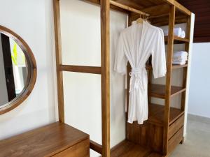 Una túnica blanca cuelga de un estante de madera. en Kedisan Panorama, en Kubupenlokan 31 fotos más