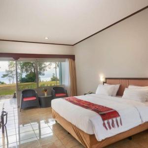 a bedroom with a large bed and a large window at Patra Comfort Parapat in Parapat
