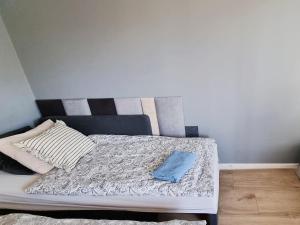 a bed with a blue pillow on top of it at Apple Apartments - Wróblewskiego PRYWATNE MIEJSCE PARKINGOWE in Łódź