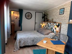 una camera da letto con un letto e un tavolo di legno di Le Clos des Passiflores a Pons Altre 48 foto