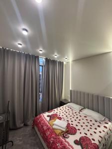 a bedroom with a bed and a window with curtains at BeST TRIP in Almaty
