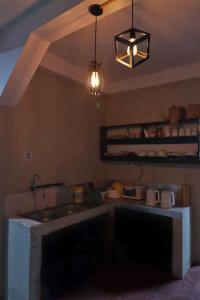 a kitchen with a sink and a counter with a light at OK hostel in Luang Prabang