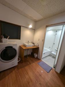 a bathroom with a sink and a washing machine at KOMINKA T8 Tomonoura in Fukuyama