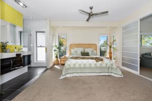 a bedroom with a large bed and a kitchen at Tropical Oasis - Creekside Townhouse by uHoliday in Pottsville