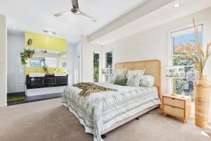 a bedroom with a large bed and a kitchen at Tropical Oasis - Creekside Townhouse by uHoliday in Pottsville