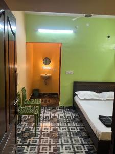 a hotel room with a bed and a bathroom at Gyani 3 in Tiruvannāmalai +5 photos