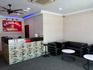a waiting room with black chairs and a counter at Gemilang Star Hotel in Port Dickson