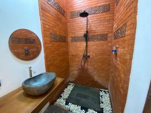 a bathroom with a bathtub with a sink in a brick wall at Villa Dewi Sri by MentariPro Bali in Buleleng