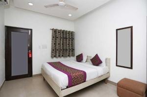 a bedroom with a bed and a chair in it at Birr Residency - Near Nizamuddin in New Delhi