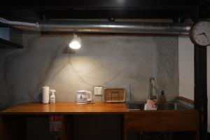 a kitchen counter with a sink and a clock at KOMINKA T8 Tomonoura in Fukuyama