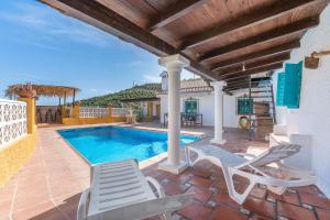 a patio with chairs and a swimming pool at Casa adelfas in Granada