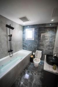 a bathroom with a tub and a toilet and a sink at Coloris Viridis room in Thessaloniki +18 photos