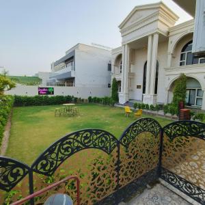 a gate in front of a building with a yard at Hotel Grand Suites in Multan