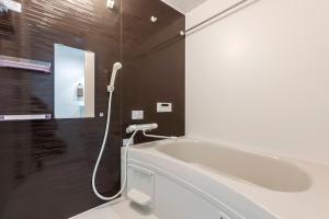 a bathroom with a bath tub and a shower at Anecis Honjin in Nagoya +43 photos
