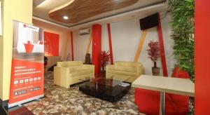 a living room with couches and a table in a room at Hotel JAV Front One in Lahat