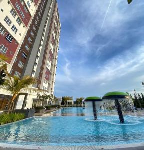 a large swimming pool with a fountain in front of buildings at TSYLuxeLoft 4BR Near UKM & Bangi Toll in Bandar Baru Bangi