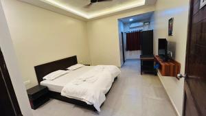 a bedroom with a bed and a television in it at Claudina baga beach in Calangute +3 photos