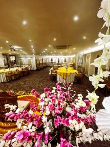 a banquet hall with tables and flowers on the floor at Grand Pallace in New Delhi