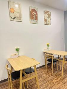 two tables and chairs in a room with white walls at Rest And Relax Hostel in Ban Mo Nae +8 photos