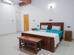 a bedroom with a wooden bed and a table at Namal Stay in Weligama