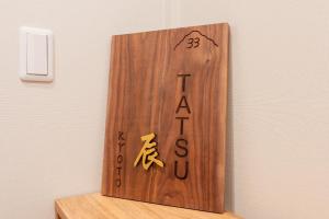 a wooden sign on a wall with writing on it at 三十三Tatsu in Kyoto