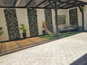 a patio with chairs and plants on a wall at Flower Apartment Cintia in Odorheiu Secuiesc